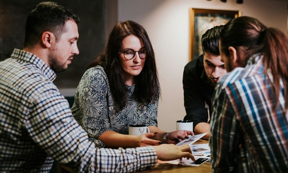 A diverse group of individuals engaged in conversation while seated around a table, fostering collaboration and connection.